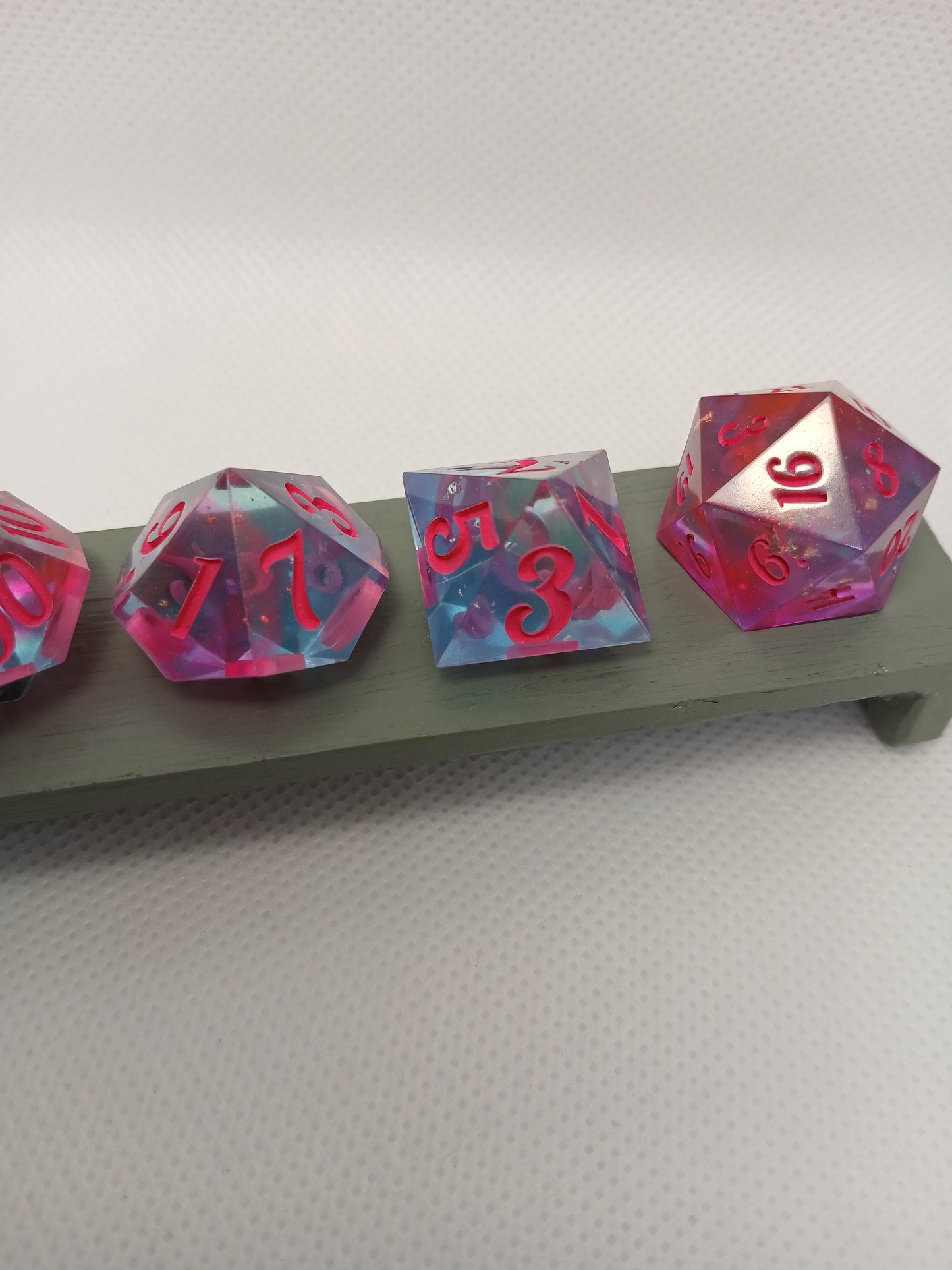 Dice set blåtransparent med rosa siffror.