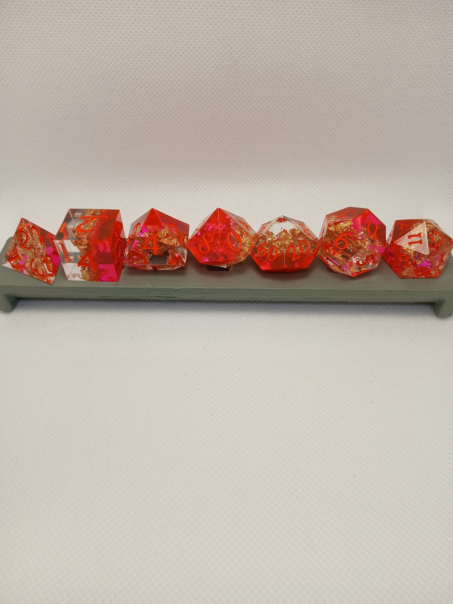 Dice set. Rosa/guldskimmer/genomskinlig med orange siffror.