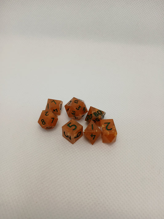 Dice set mini orange med guldglitter och gröna siffror.