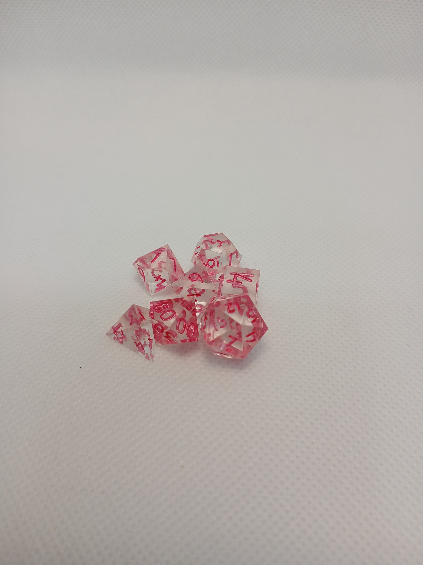 Dice set mini Genomskinliga med rosa siffror.