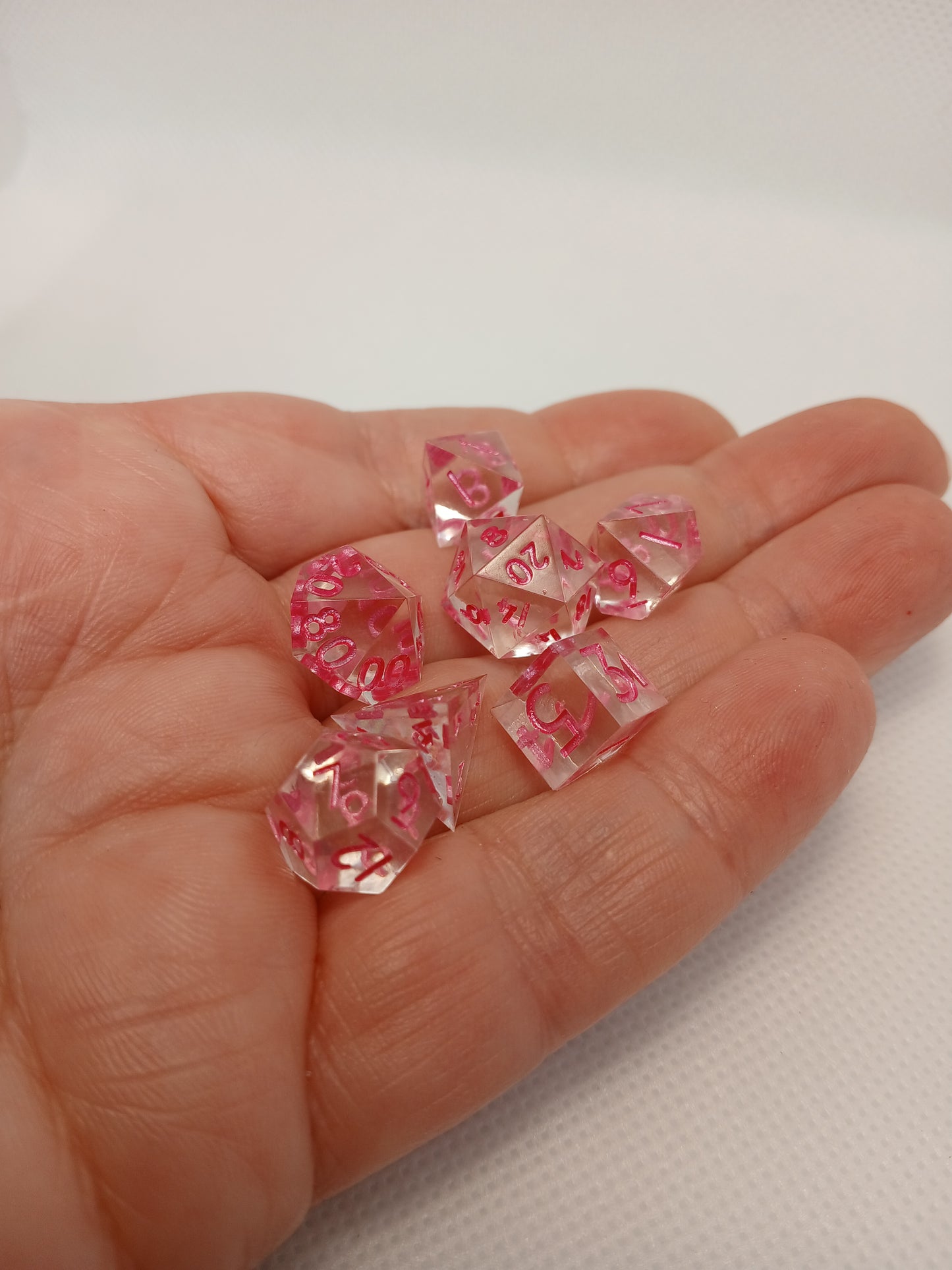 Dice set mini Genomskinliga med rosa siffror.