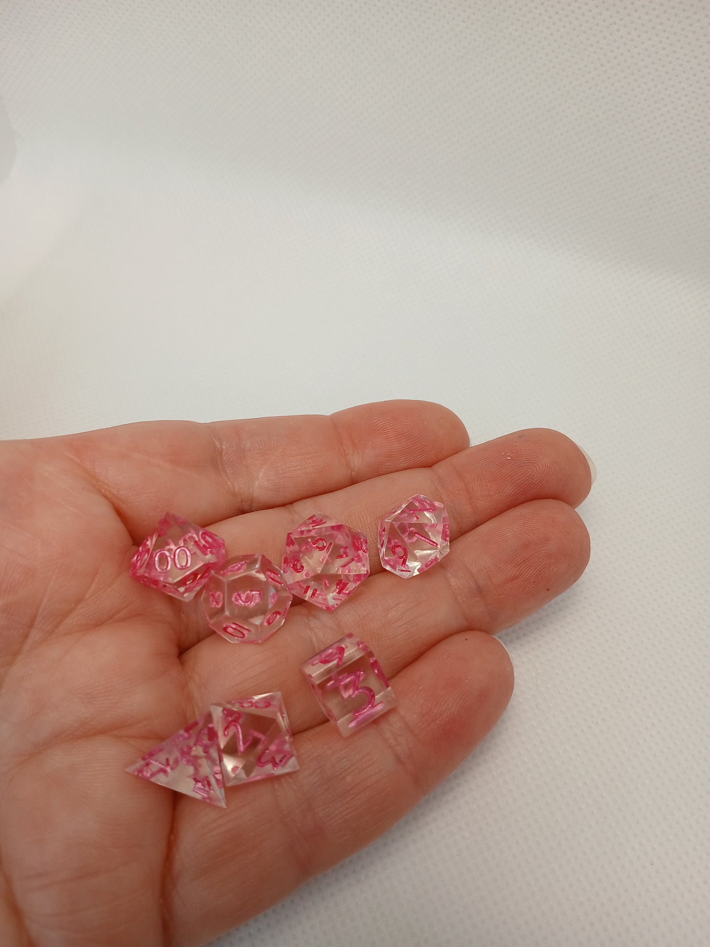 Dice set mini Genomskinliga med rosa siffror.