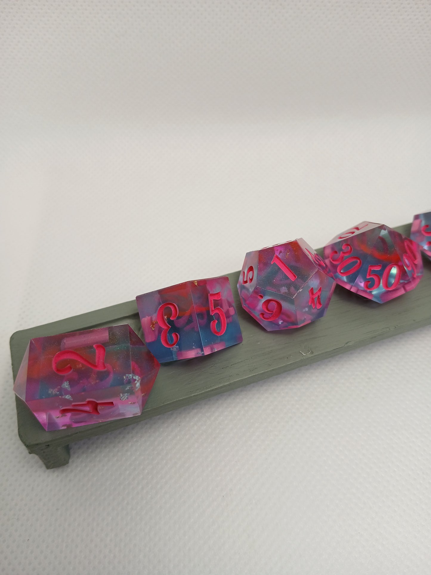 Dice set blåtransparent med rosa siffror.