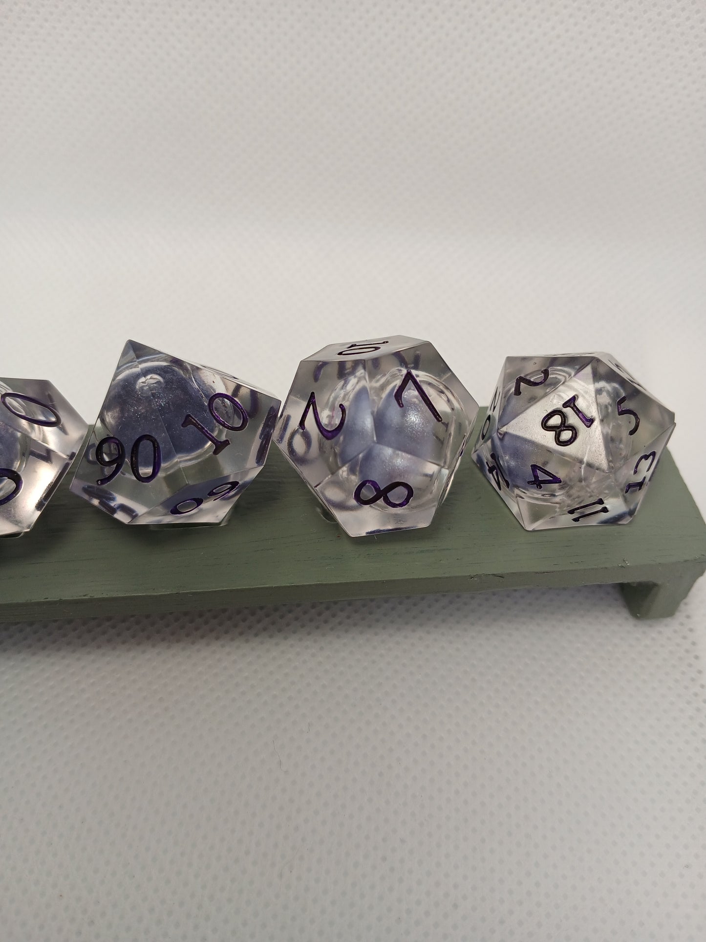 Dice set. Genomskinlig med flytande mitt, lila siffror.