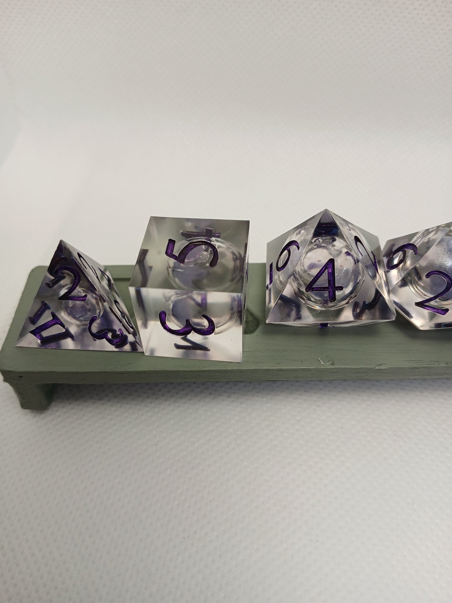 Dice set. Genomskinlig med flytande mitt, lila siffror.