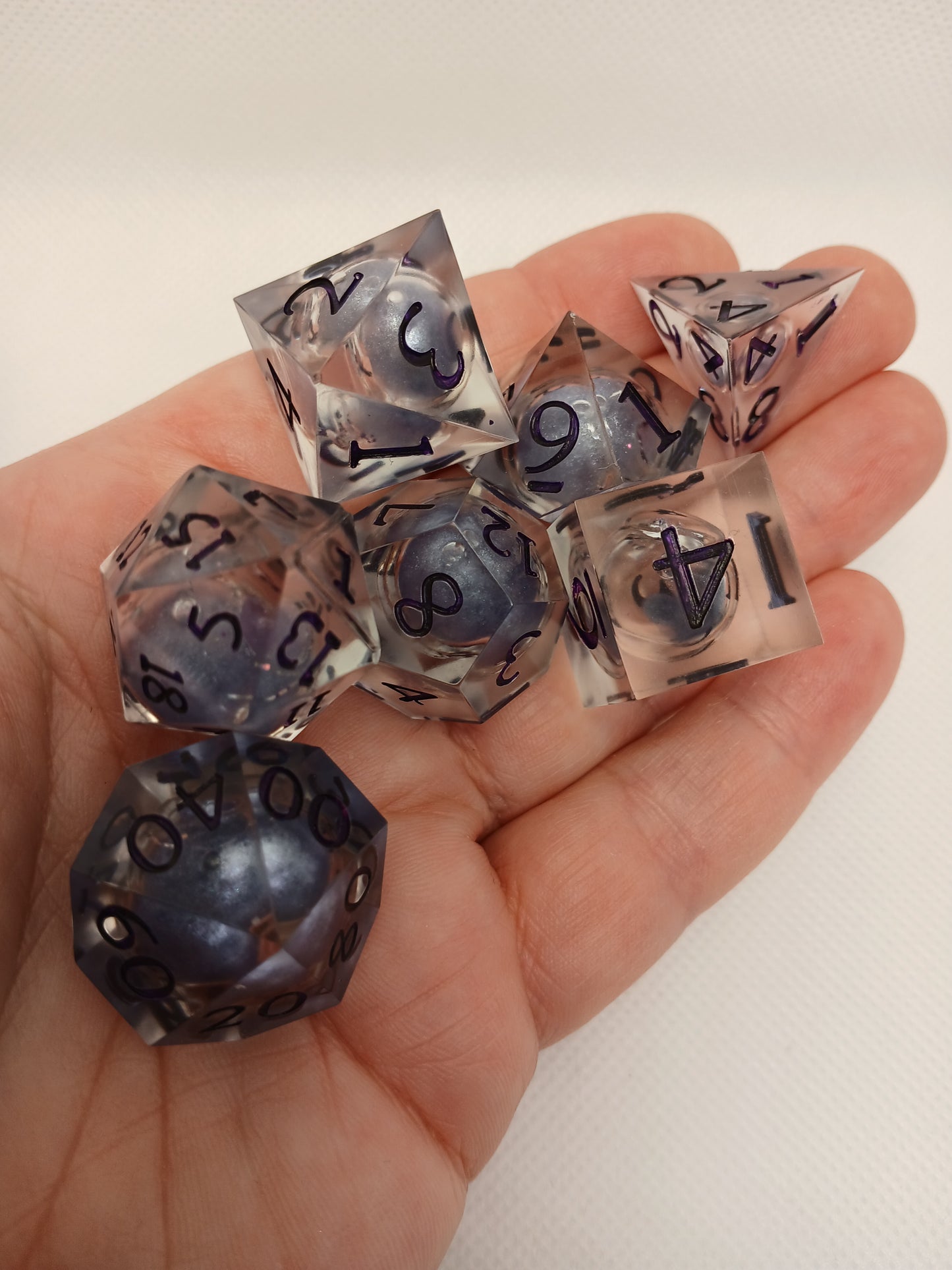 Dice set. Genomskinlig med flytande mitt, lila siffror.