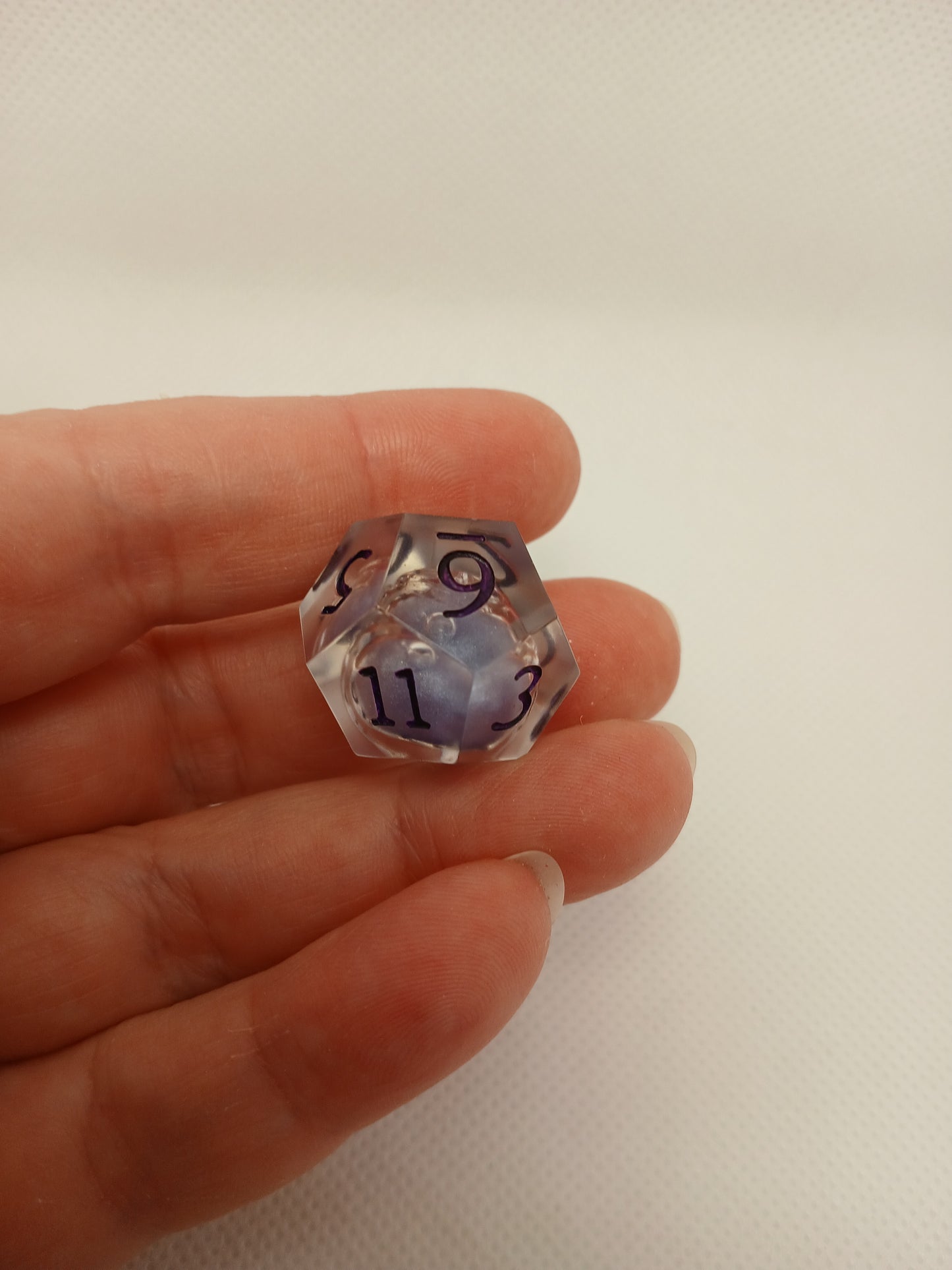 Dice set. Genomskinlig med flytande mitt, lila siffror.