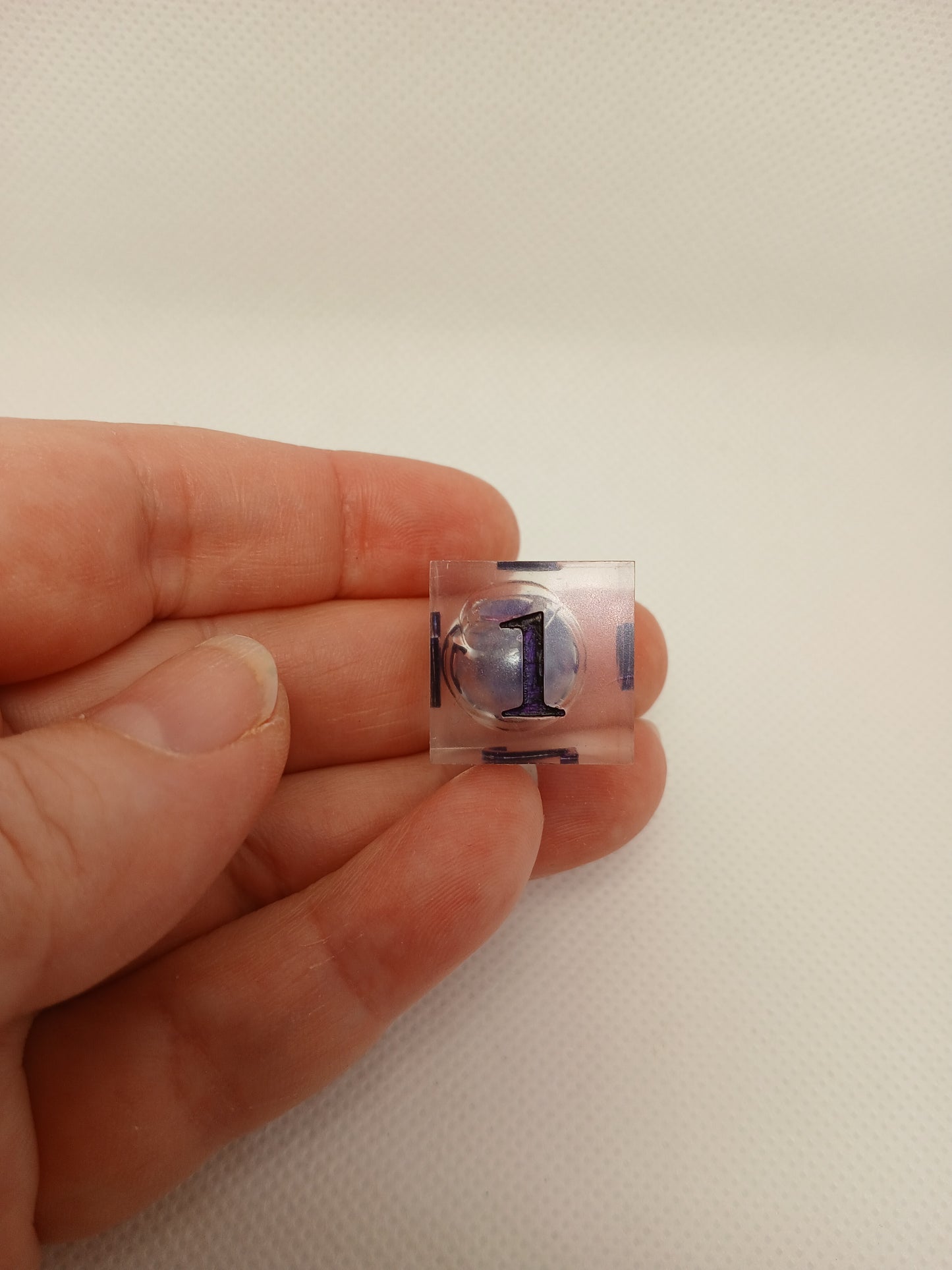 Dice set. Genomskinlig med flytande mitt, lila siffror.