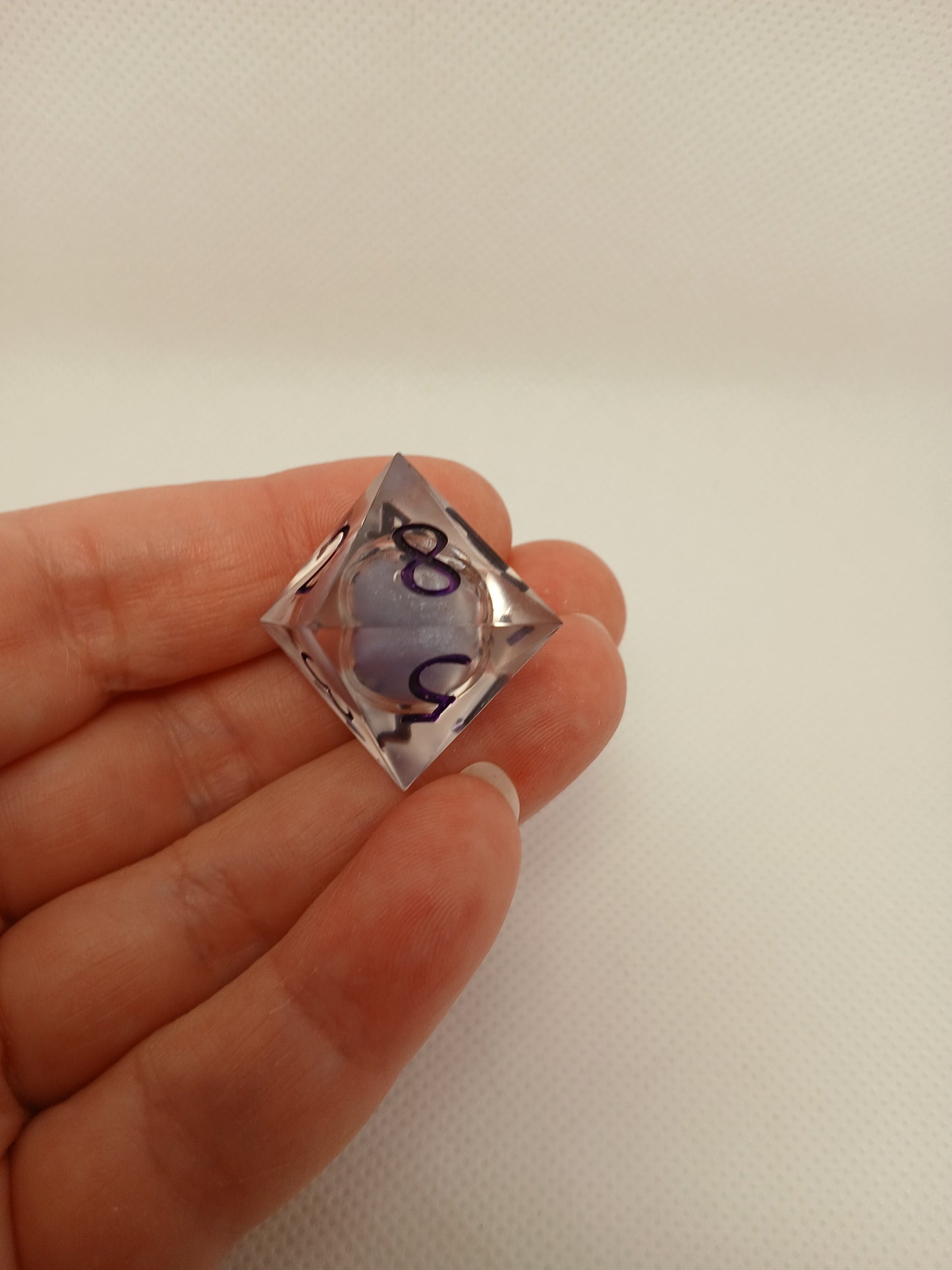 Dice set. Genomskinlig med flytande mitt, lila siffror.