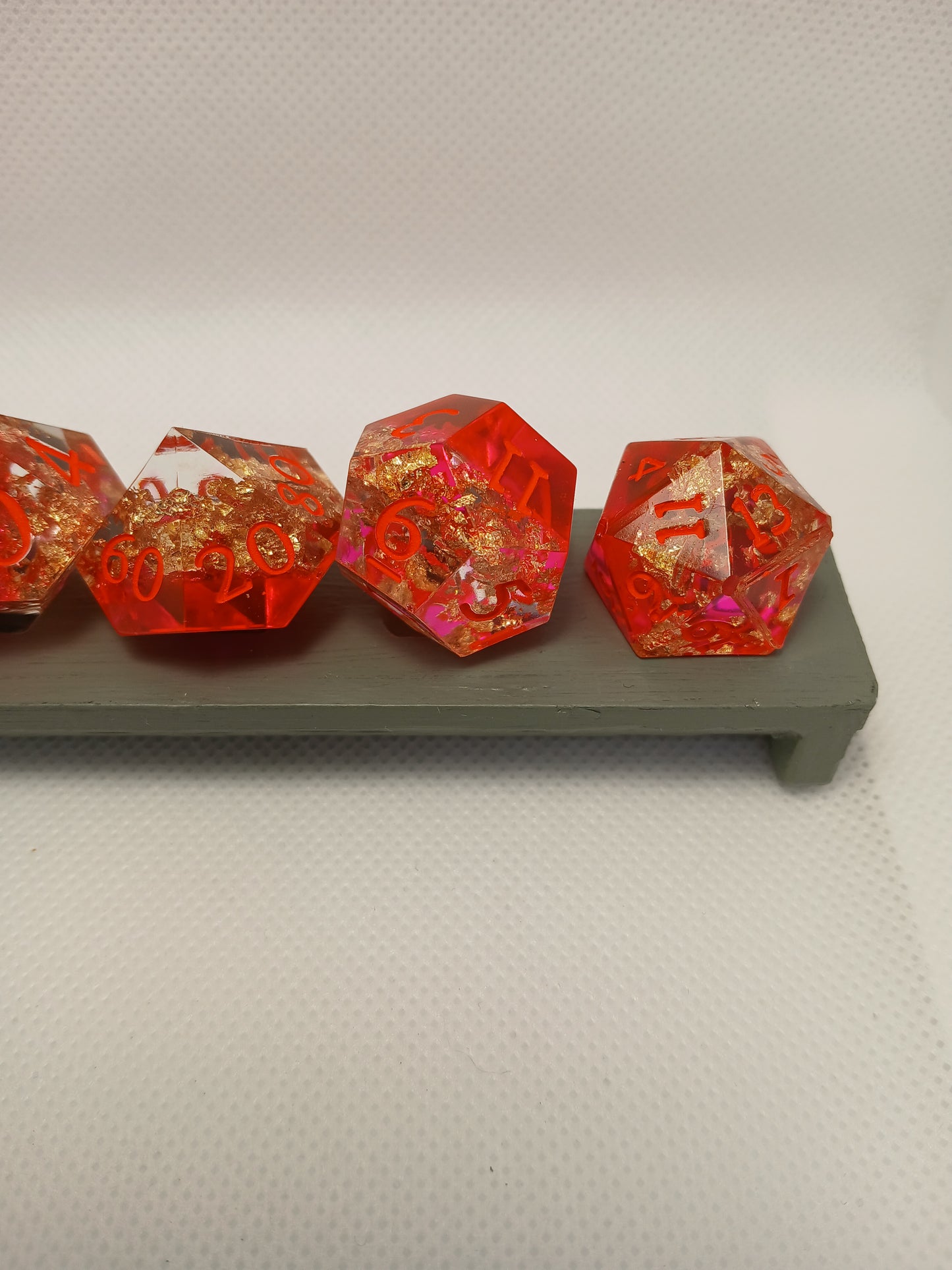 Dice set. Rosa/guldskimmer/genomskinlig med orange siffror.