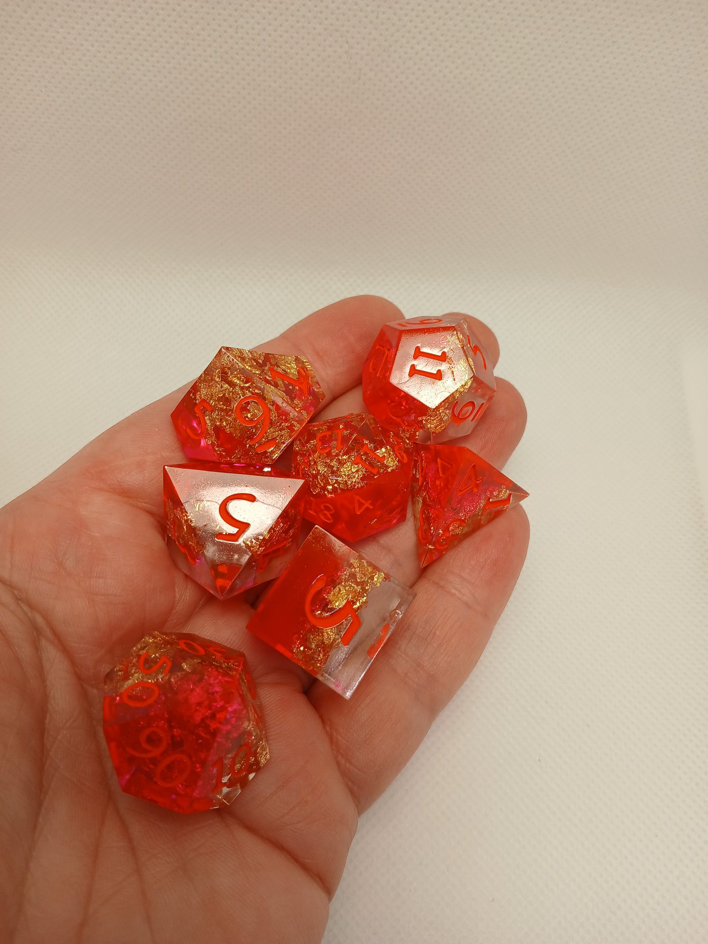 Dice set. Rosa/guldskimmer/genomskinlig med orange siffror.