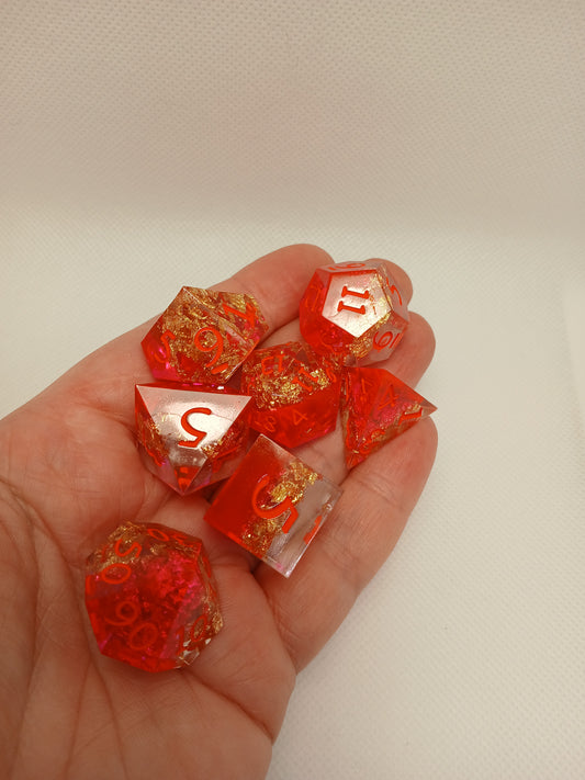 Dice set. Rosa/guldskimmer/genomskinlig med orange siffror.