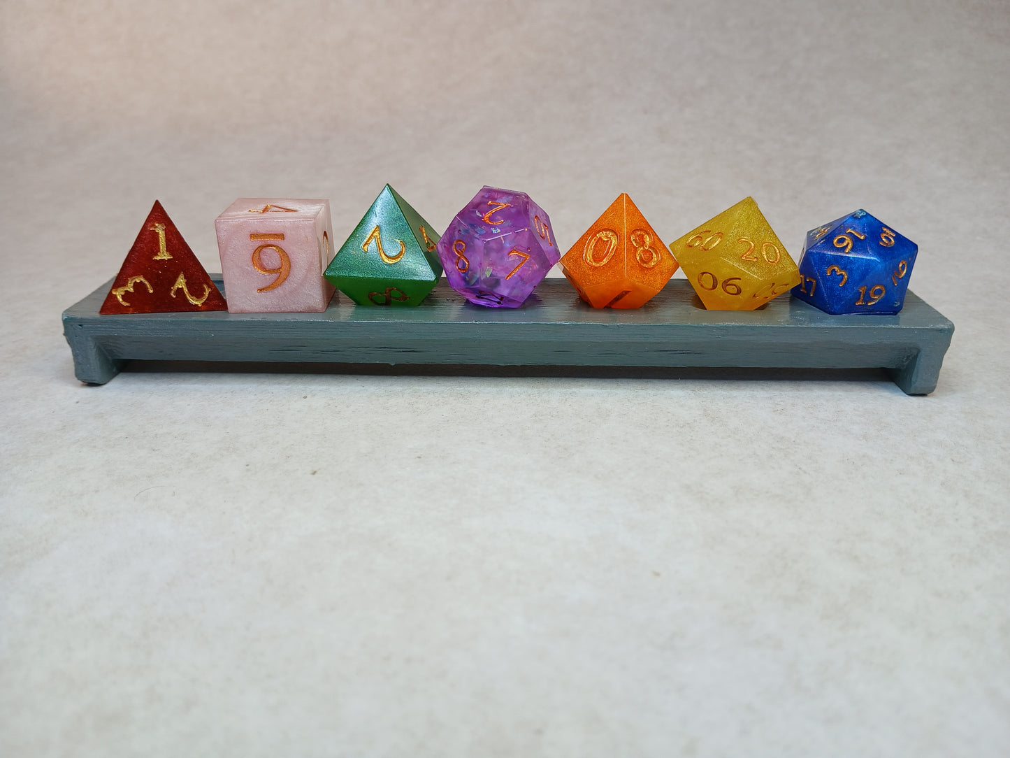 Dice set regnbågsfärger med siffror i guldfärg