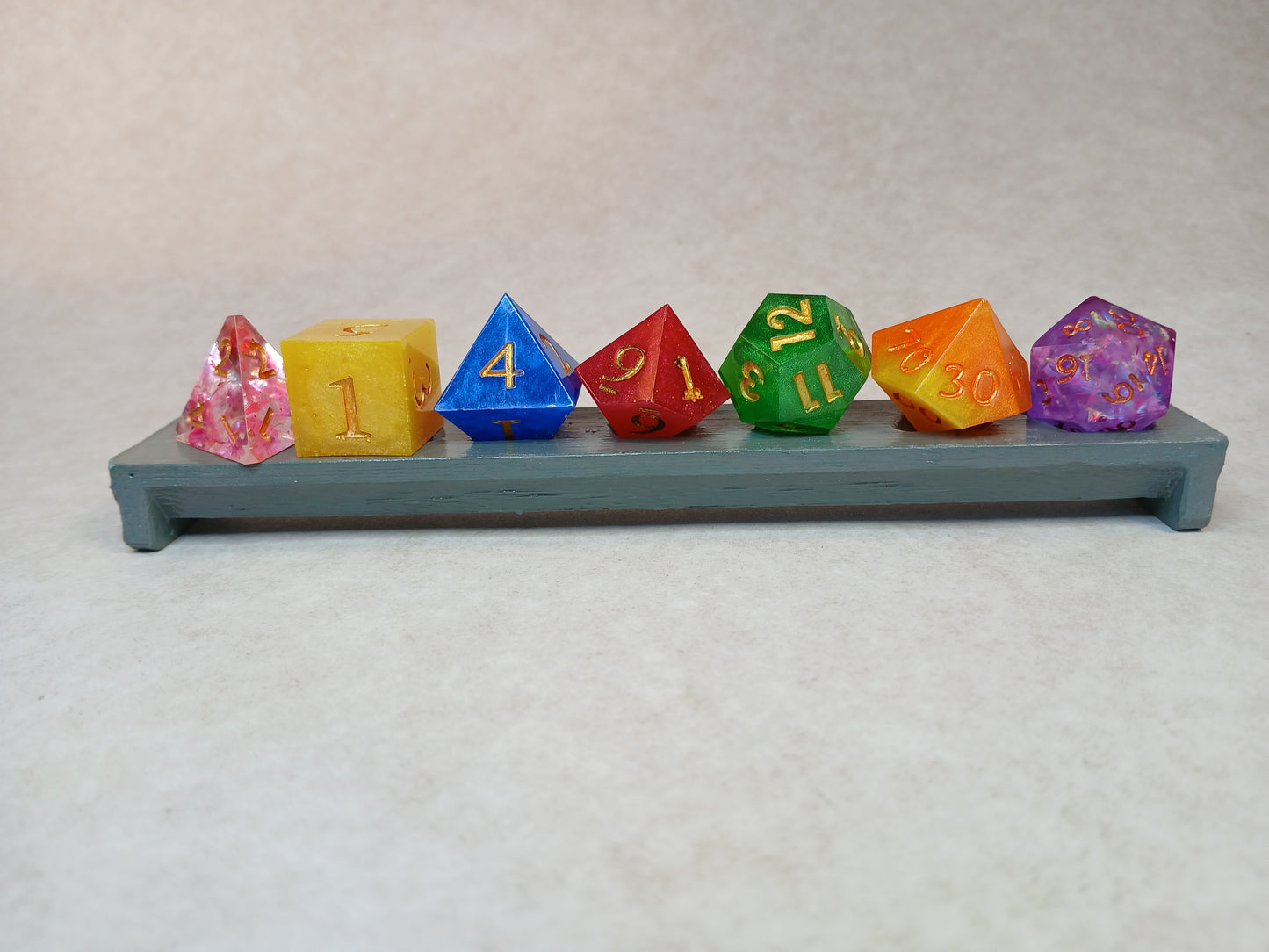Dice set regnbågsfärger med siffror i guldfärg